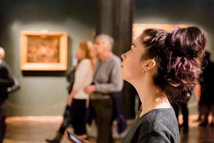 Frau im Museum Frau schaut auf Gemälde im Kunstmusuem